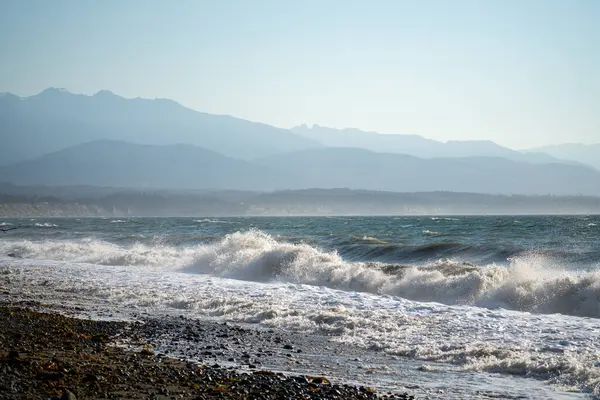 Wellen Krachen Auf Den Strand Mit Nebligen Bergen Hintergrund — Stockfoto