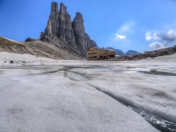 Re Alberto mountain hut with a frozen lake and the Towers of Vajolet mounts, Dolomites, Italy — Stock Photo, Image