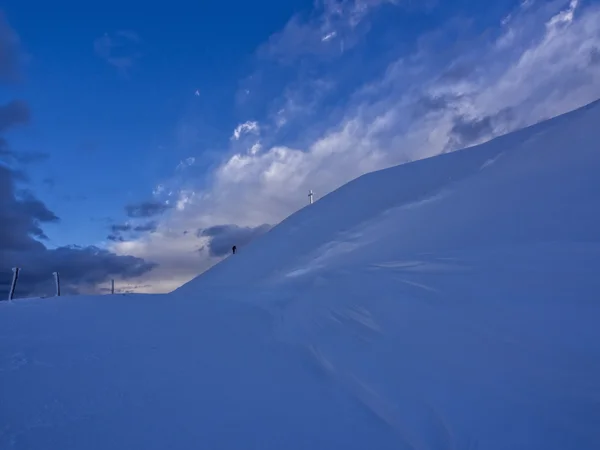 Hiker reaching the frozen summit cross of mount Catria in winter, Apennines, Italy — Stock Photo, Image