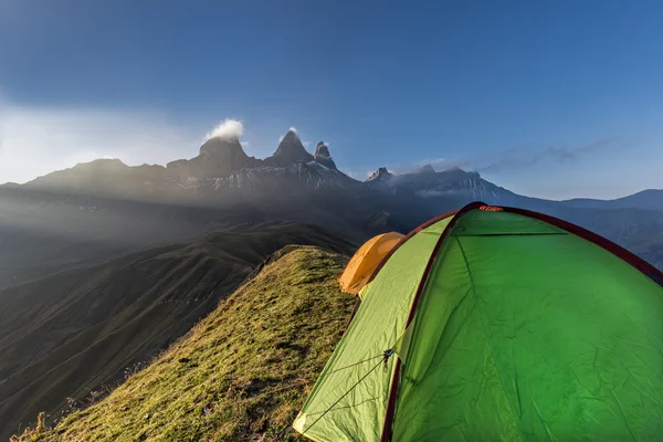 Tendas em uma borda de montanha em frente ao Aiguille d 'Arves ao sol — Fotografia de Stock