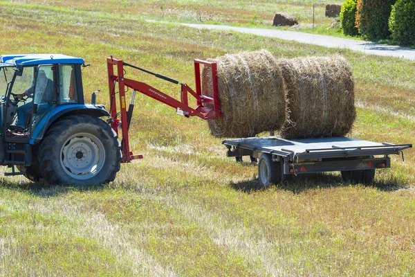 Traktor laddar höbalar i ett fält, Gubbio, Umbrien, Italien — Stockfoto