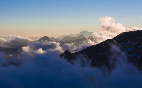 Alpina toppar i molnen sett från Mantova hut på Monte Rosa, Royaltyfria Stockbilder