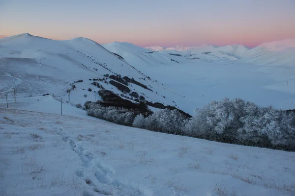 Footprints on the snow, sunset on the hills in winter, Sibillini — Stock Photo, Image