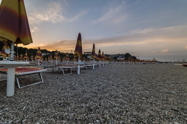 Ombrelloni vicino alla città di Numana al tramonto, Conero NP, Ma Immagine Stock