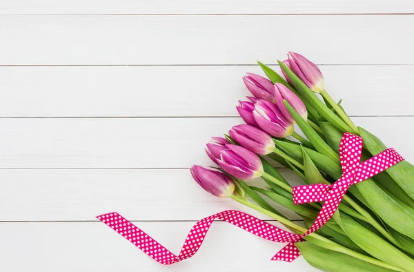 Bouquet of bright pink tulips on white wooden background. Top view — Stock Photo, Image