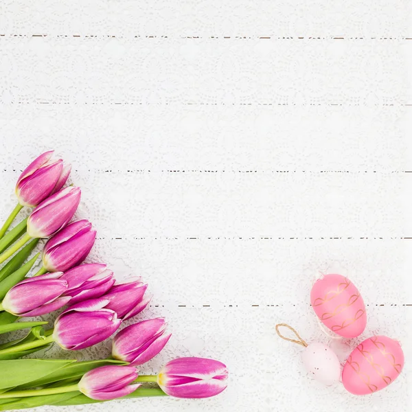 Osterhintergrund. Strauß von Tulpen und dekorativen Eiern auf weißem Holzgrund. — Stockfoto