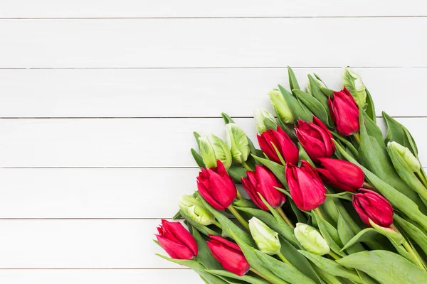 Bouquet of white and red tulips on white wooden background. Top view — Stock Photo, Image