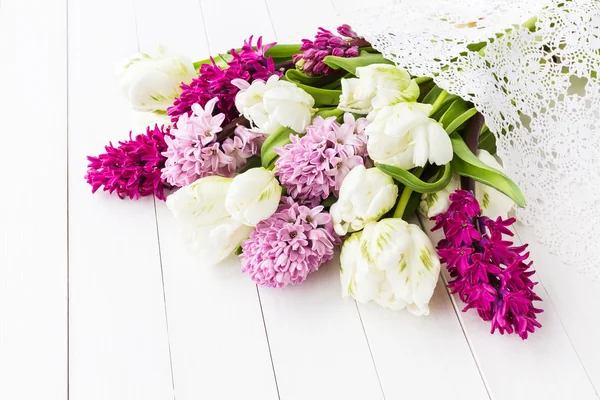 Weiße Tulpen und rosa Hyazinthen auf weißem Holztisch. Hintergrund der Feiertage — Stockfoto