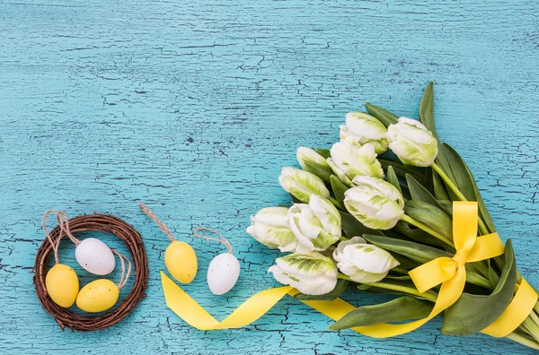 Fundo de Páscoa com flores brancas e ovos decorativos em pequeno ninho — Fotografia de Stock
