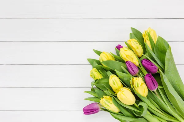 Bouquet of yellow and pink  tulips on white wooden background. Top view — Stock Photo, Image
