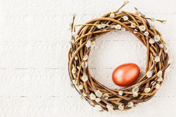Húsvéti fűzfa koszorú piros húsvéti tojást fehér terítő. Felülnézet — Stock Fotó