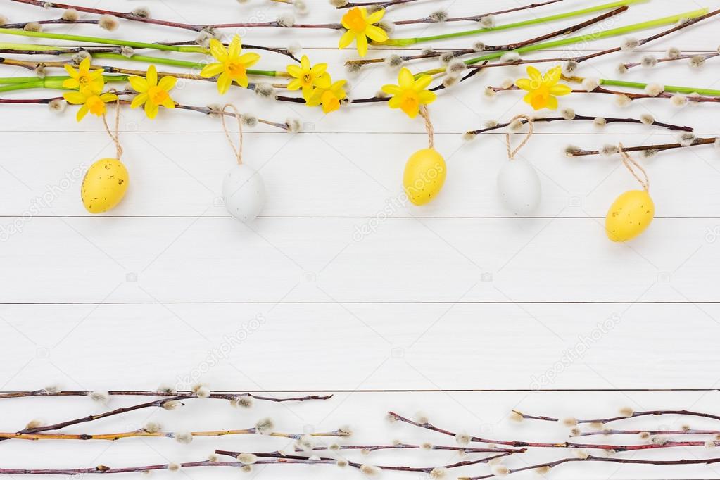 Easter background with decorative Easter eggs, narcissus  and willow tree branch. Copy space
