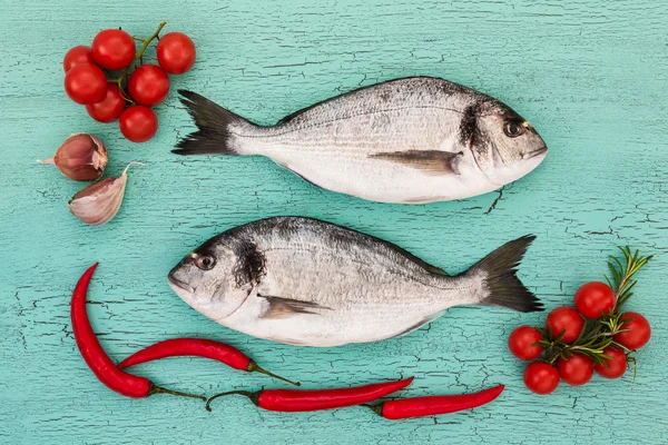 Peixe dorado fresco com legumes na mesa azul. Espaço de cópia — Fotografia de Stock