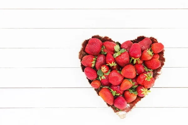 Fraises fraîches dans une assiette sur une table en bois blanc, espace de copie. Coeur de fraise — Photo