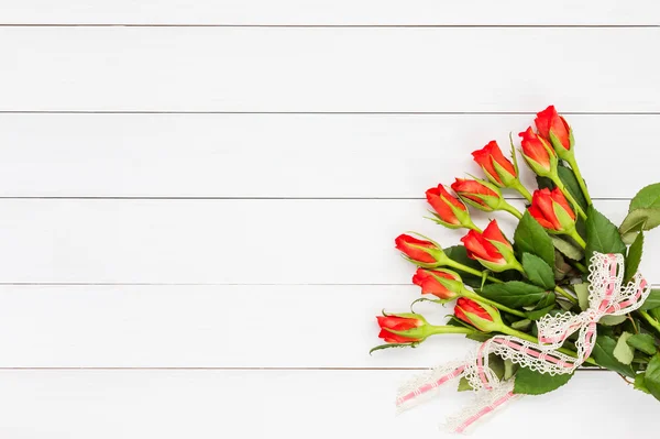 Bouquet of red roses decorated with lace on white wooden background. Copy space — Stock Photo, Image