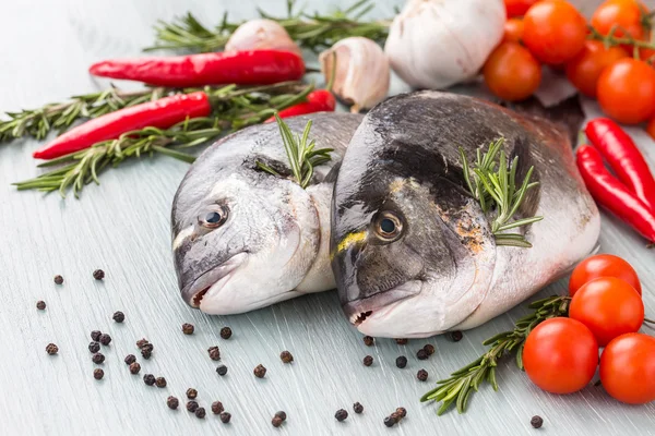 Nyers friss dorado hal, zöldségek és fűszerek az asztalon — Stock Fotó