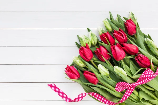 Bouquet de tulipes rouges et blanches sur fond de bois blanc . — Photo