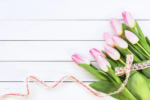 Strauß rosa Tulpen mit Band auf weißem Holzhintergrund dekoriert — Stockfoto