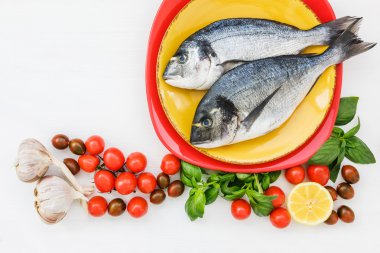 İki taze dorado Balık plaka ve sebze beyaz masanın üzerinde. Üstten Görünüm