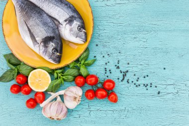 Mavi masada domates taze dorado balık sarı plaka üzerinde. Üstten Görünüm