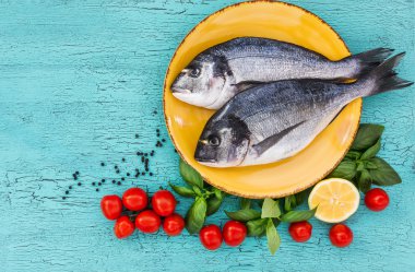 Çiğ dorado Balık plaka, mavi masada. Üstten Görünüm, kopya alanı.