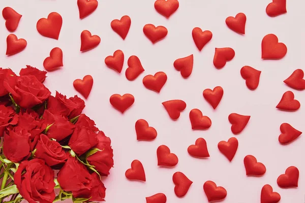 Conceito do Dia dos Namorados. Corações vermelhos e rosas vermelhas buquê de flores em um fundo rosa. Depósito plano — Fotografia de Stock