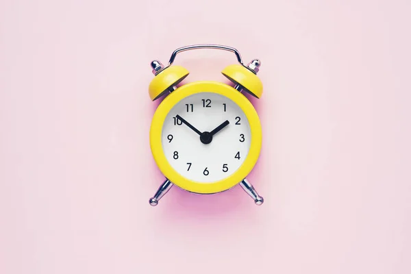 Yellow vintage alarm clock on a pink background. Daylight saving concept. Flat lay, copy space. — Stock Photo, Image