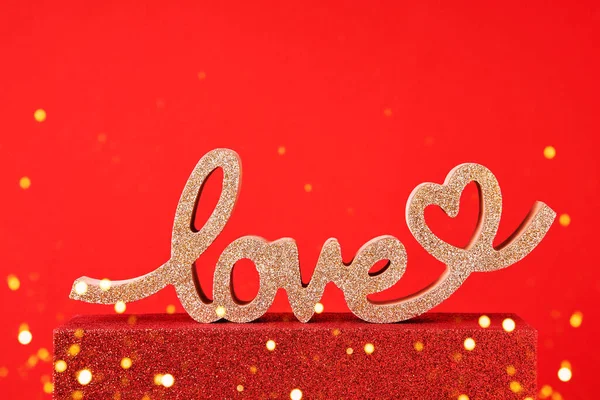 Conceito do Dia dos Namorados. AMOR palavra dourada em um pódio vermelho com espaço de cópia. Vista superior, espaço de cópia — Fotografia de Stock