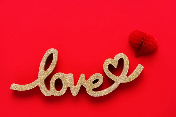 Coração vermelho e palavra dourada AMOR em um fundo vermelho. Conceito do Dia dos Namorados. — Fotografia de Stock
