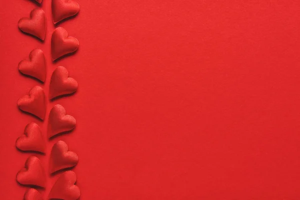 Conceito do Dia dos Namorados. Corações vermelhos num fundo vermelho. Vista superior, espaço de cópia — Fotografia de Stock