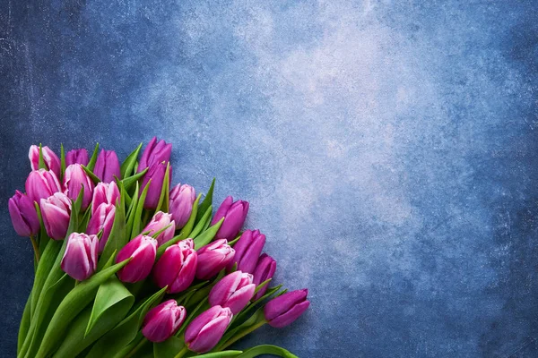 Buquê de tulipas roxas em um fundo azul. Flat lay, espaço de cópia — Fotografia de Stock
