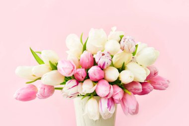 Pembe ve beyaz laleler pembe arka planda vazoda. Tatil arka planı, kopyalama alanı. Sevgililer Günü, Anneler Günü, doğum günü kutlaması konsepti.