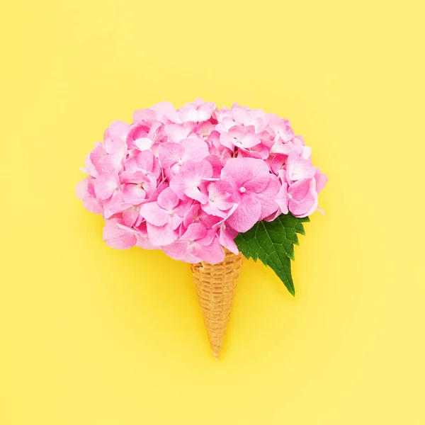 Hortensia rosa o flor de hortensia en cono de helado de gofre sobre un fondo amarillo. Día de las Madres, Concepto de San Valentín. — Foto de Stock