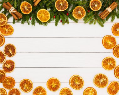 Christmas background. Christmas fir tree, dried oranges on white wooden background with copy space