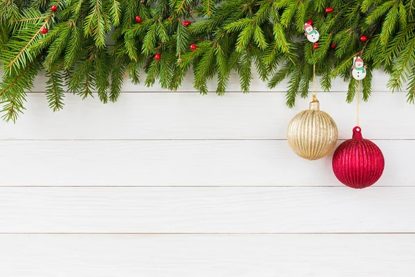Weihnachtlicher Hintergrund. Tanne mit Dekoration auf weißem Holzbretthintergrund, Kopierraum. — Stockfoto