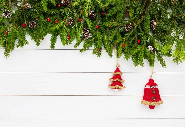 Weihnachtlicher Hintergrund. Tanne mit Dekoration auf weißem Holzbretthintergrund, Kopierraum — Stockfoto