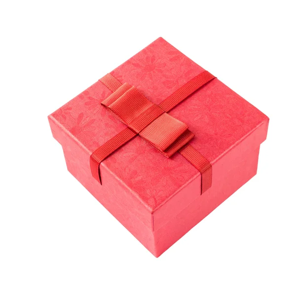 Czerwone pudełko z czerwoną wstążką na białym tle nad białym. — Zdjęcie stockowe