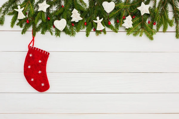 Weihnachtlicher Hintergrund. Tannenbaum mit Dekoration, rote Socke auf weißem Holzbrett Hintergrund mit Kopierraum. — Stockfoto