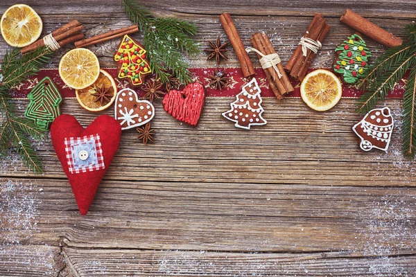 Weihnachten hölzernen Hintergrund mit hausgemachten Lebkuchen und rotem Herz. getönter, weicher Fokus — Stockfoto