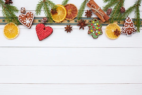 Weihnachtshintergrund mit Weihnachtsplätzchen, Zimt, Schleife, Weihnachtsbaumzweig. — Stockfoto