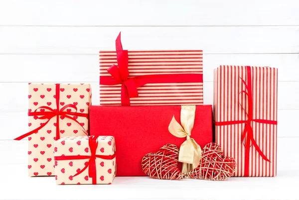 Caixas de presentes embrulhadas e dois corações vermelhos no backgroun de madeira branca — Fotografia de Stock