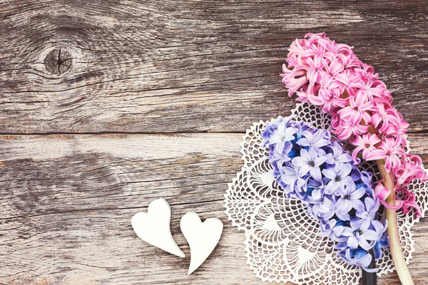 Zwei dekorative Herzen und frische Hyazinthen auf gealtertem Holzgrund. Valentinstag-Konzept. — Stockfoto
