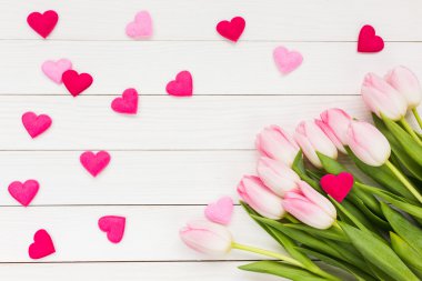 Pembe Laleler ve kalp Beyaz ahşap zemin üzerinde. Sevgiliye arka plan. Üstten Görünüm