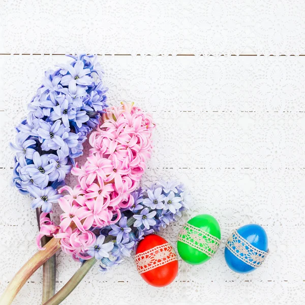 Easter eggs and hyacinths on white tablecloth. Top view — Stock Photo, Image