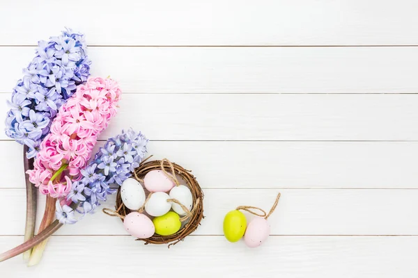 Friss Jácintok és dekoratív húsvéti tojások kis fészek fehér asztalra. Felülnézet — Stock Fotó
