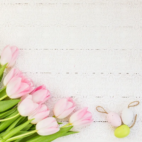 Frische Tulpen und dekorative Ostereier auf weißer Tischdecke. Ansicht von oben — Stockfoto