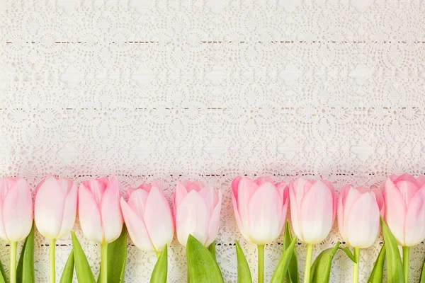 Rand aus rosa Tulpen auf weißer Vintage-Tischdecke. Ansicht von oben — Stockfoto