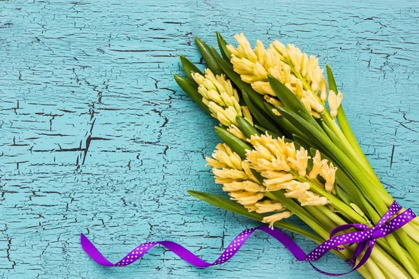 Strauß gelber Hyazinthen auf hellblauem Hintergrund. Ansicht von oben — Stockfoto