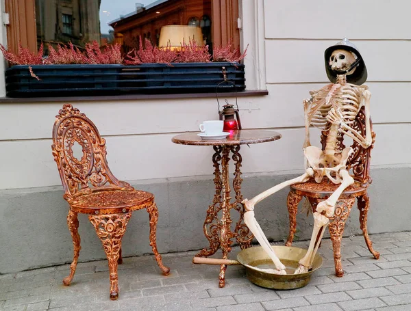Riga, Letonya. İskelet 13 Kresli 'nin önünde oturuyor. Riga Old Town 'un göbeğindeki kafe.