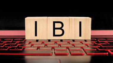 Dizüstü bilgisayarında IBI metni olan tahta bloklar, iş konsepti